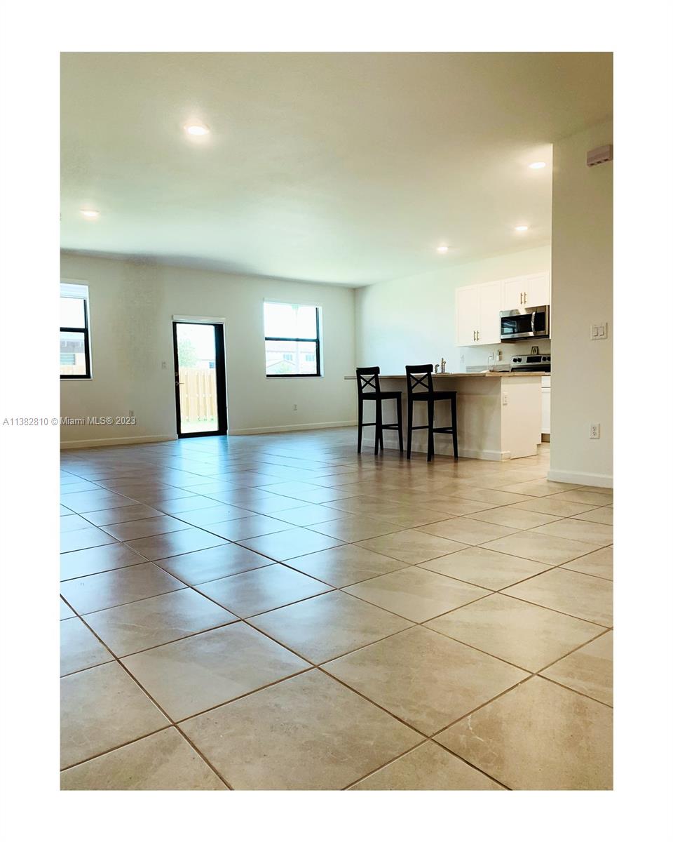11909 Southwest 244th Street, Unit 11909 Homestead, FL 33032 - Photo 5 of 45 a view of open kitchen with granite countertop a sink and a window