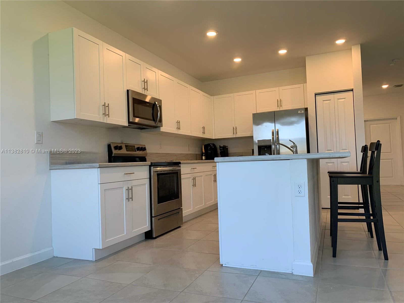 11909 Southwest 244th Street, Unit 11909 Homestead, FL 33032 - Photo 7 of 45 a kitchen with a sink a stove and refrigerator