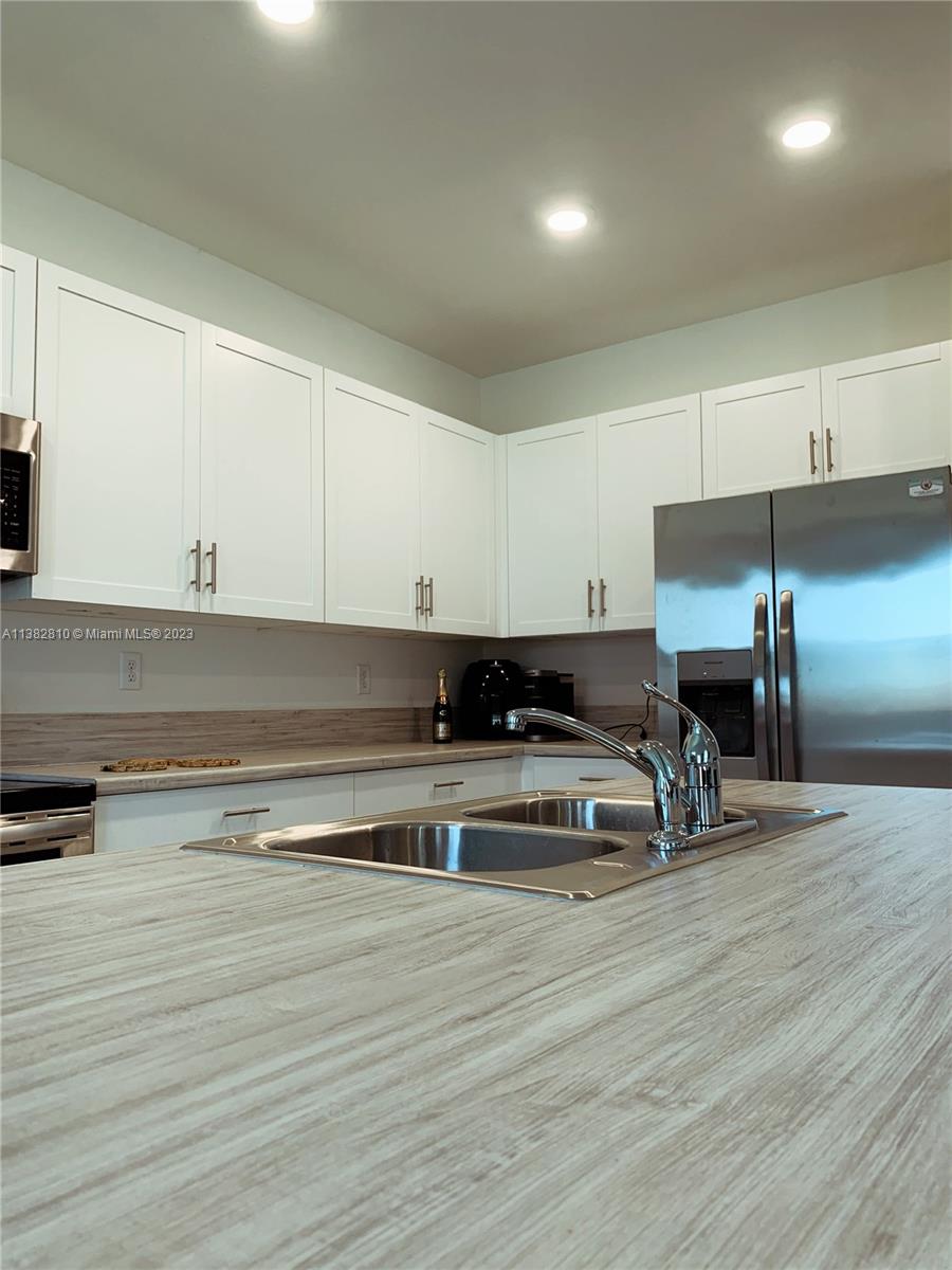 11909 Southwest 244th Street, Unit 11909 Homestead, FL 33032 - Photo 8 of 45 a kitchen view with wooden floor and a sink