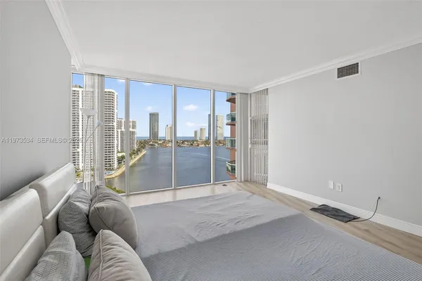 a bedroom with a large bed and large window