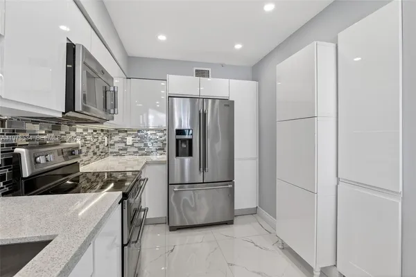 a kitchen with appliances a sink and cabinets