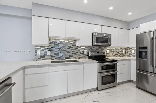 a kitchen with stainless steel appliances a sink stove and cabinets