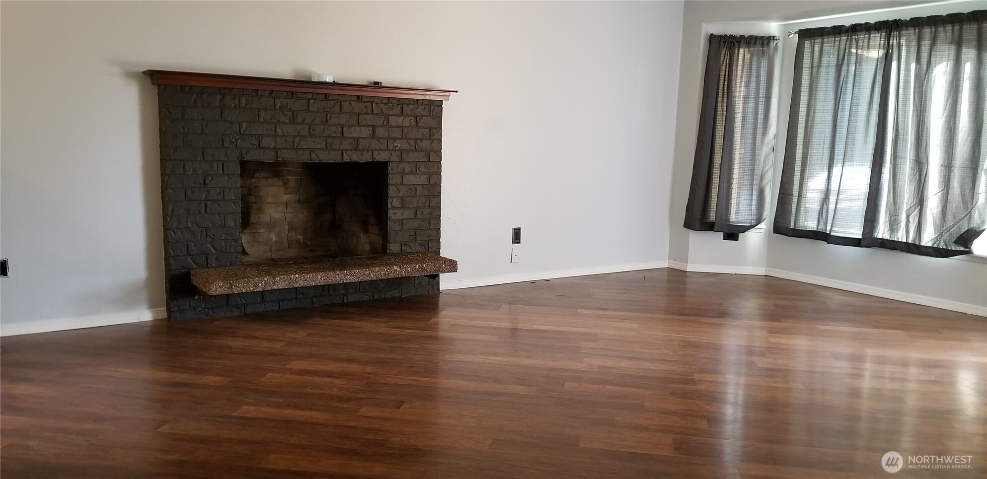 9210-9212 204th Street East Graham, WA 98338 - Photo 13 of 16 an empty room with wooden floor and fireplace