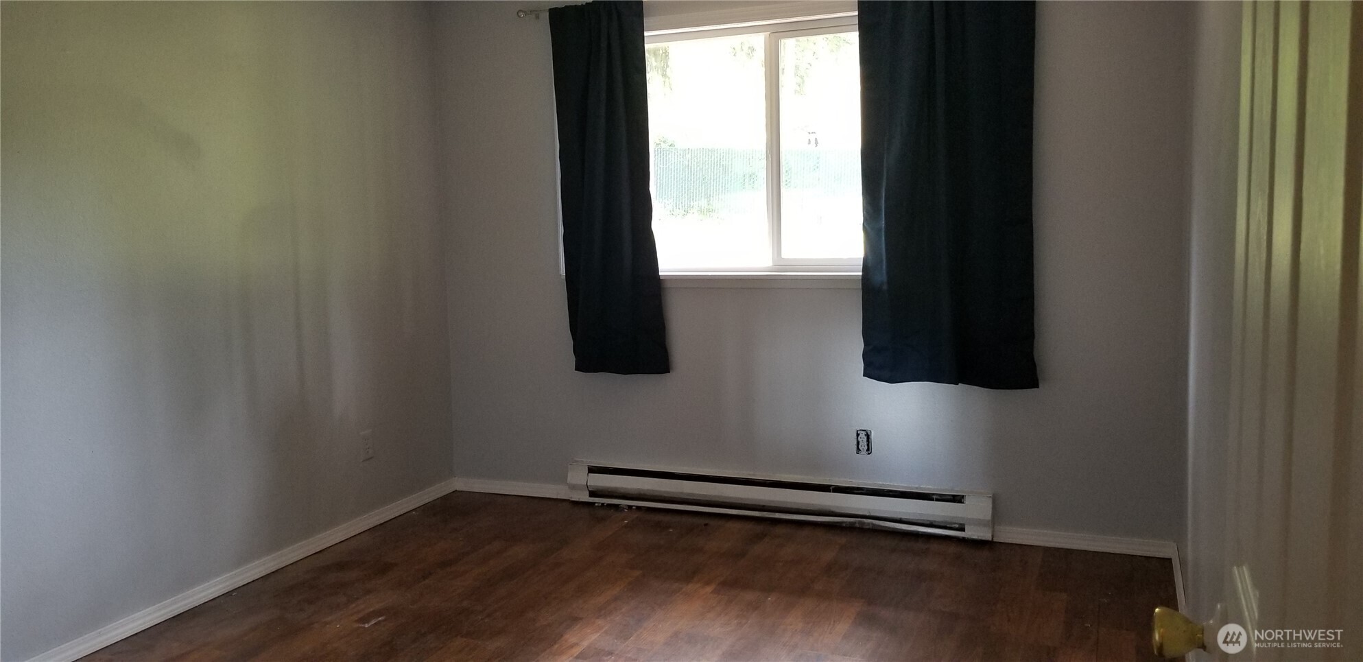 9210-9212 204th Street East Graham, WA 98338 - Photo 14 of 16 a view of an empty room with wooden floor and a window