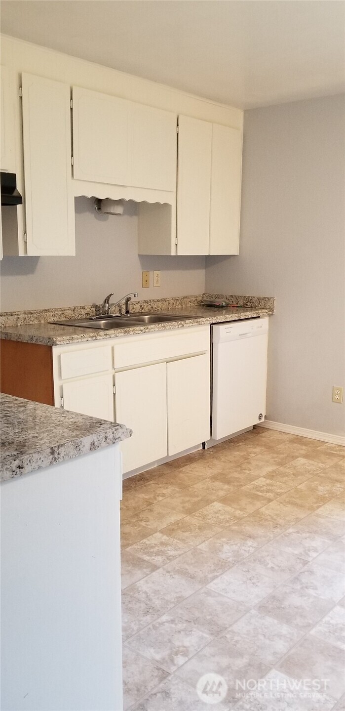 9210-9212 204th Street East Graham, WA 98338 - Photo 16 of 16 a kitchen with granite countertop a sink a stove and cabinets