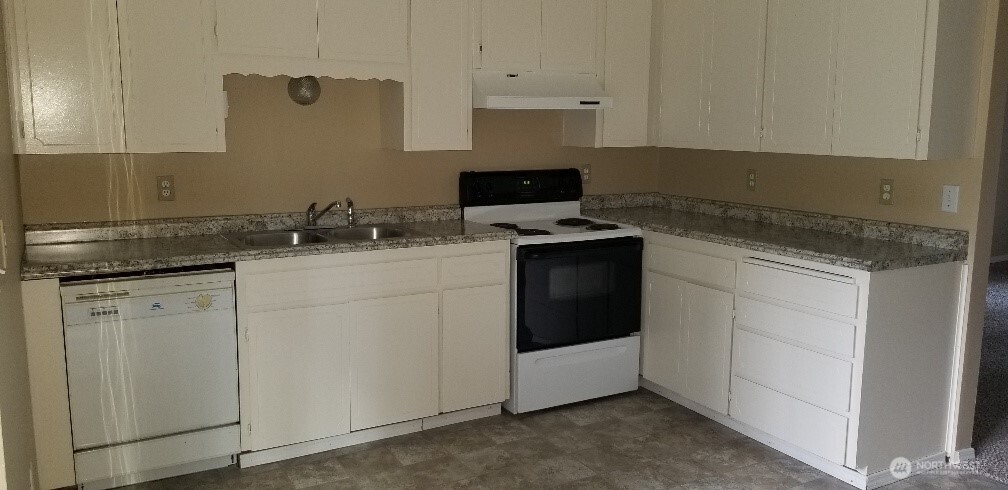 9210-9212 204th Street East Graham, WA 98338 - Photo 6 of 16 a kitchen with granite countertop cabinets stainless steel appliances and a sink