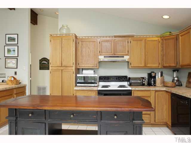 2519 Baptist Road Durham, NC 27703 - Photo 3 of 8 a kitchen with granite countertop a refrigerator a stove a sink dishwasher and white cabinets with wooden floor