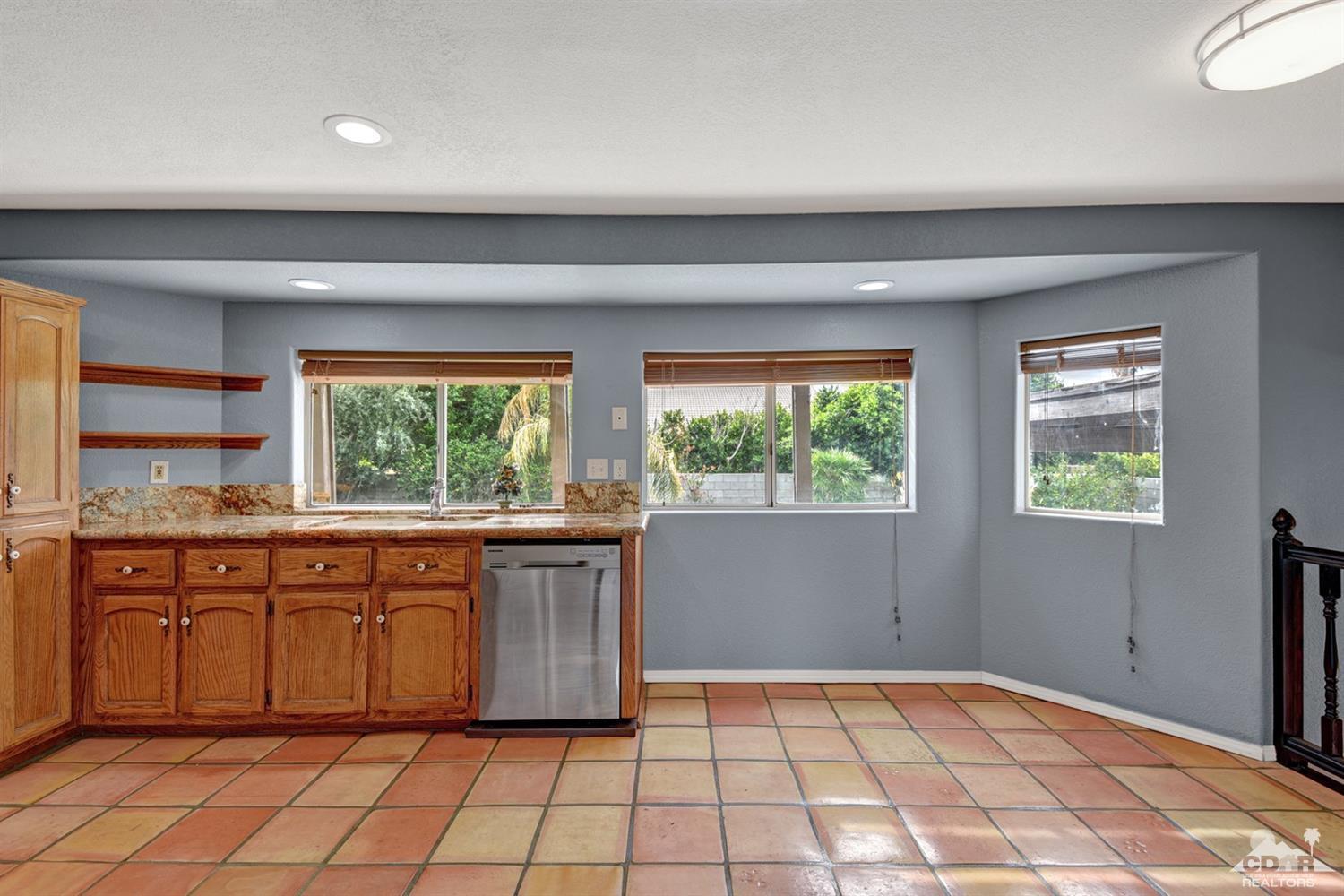 68889 Risueno Road Cathedral City, CA 92234 - Photo 14 of 29 a large kitchen with granite countertop a stove a sink and a window