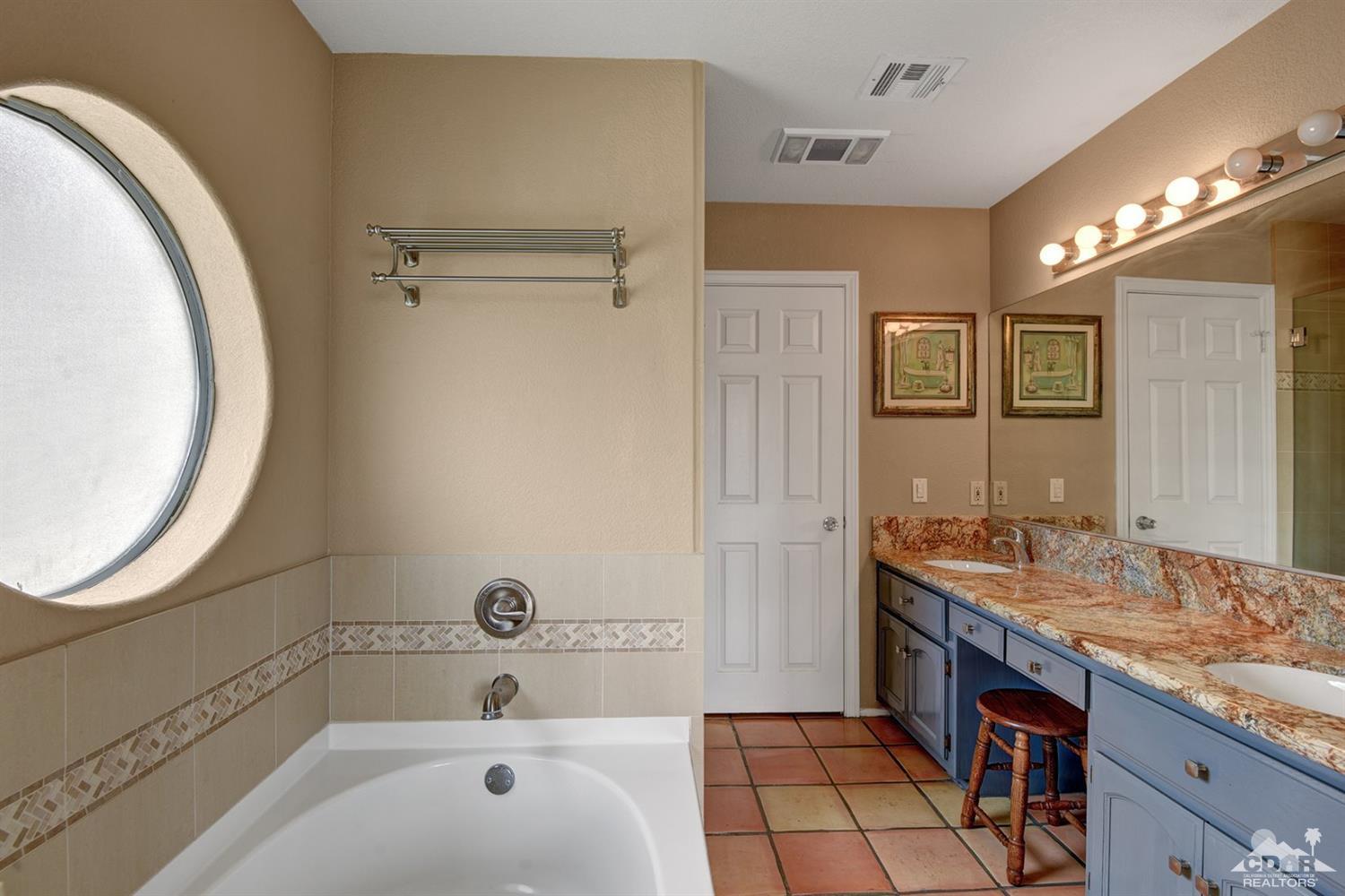 68889 Risueno Road Cathedral City, CA 92234 - Photo 17 of 29 a bathroom with a granite countertop sink a mirror and a bathtub
