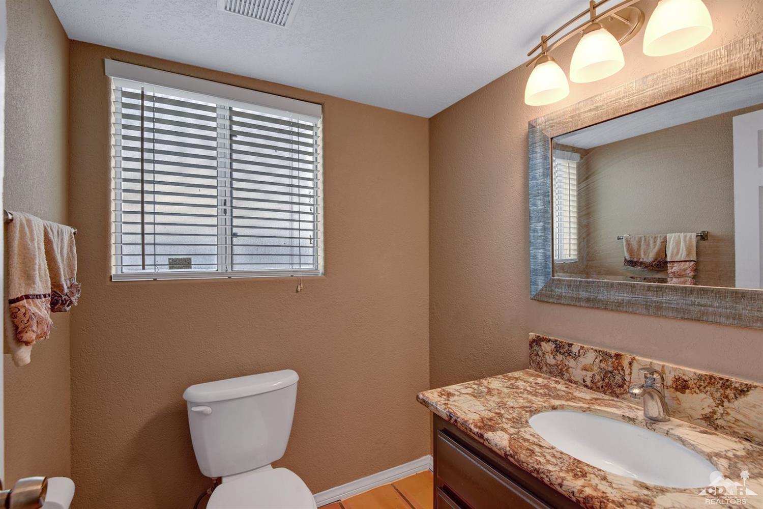 68889 Risueno Road Cathedral City, CA 92234 - Photo 20 of 29 a bathroom with a toilet sink and mirror