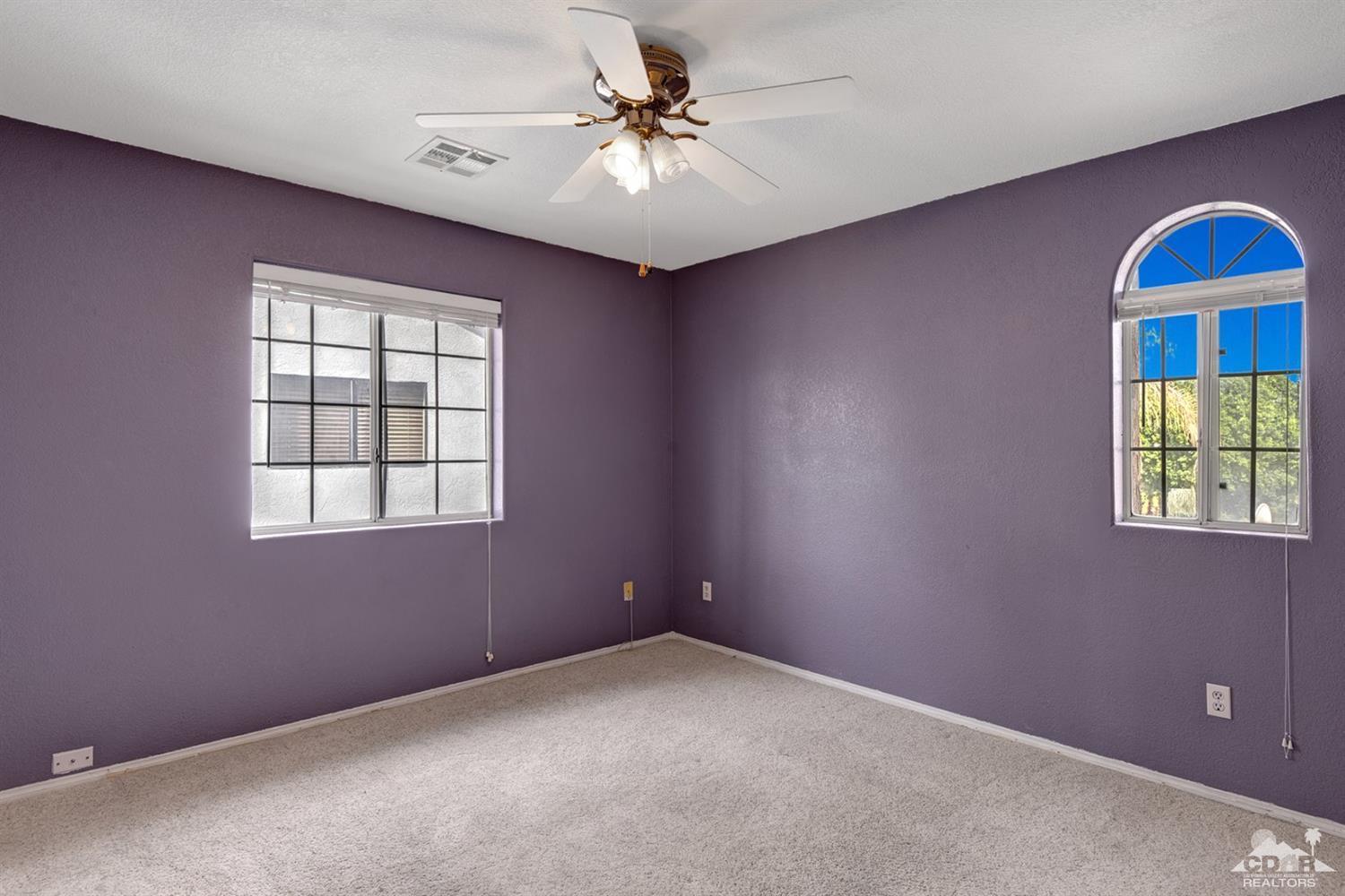 68889 Risueno Road Cathedral City, CA 92234 - Photo 21 of 29 an empty room with windows and fan
