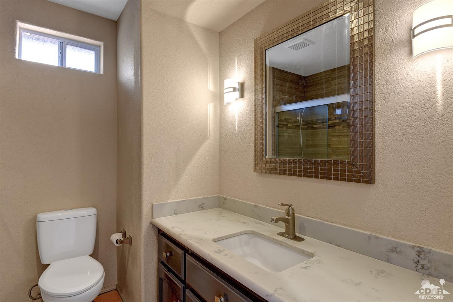 68889 Risueno Road Cathedral City, CA 92234 - Photo 23 of 29 a bathroom with a toilet sink and mirror