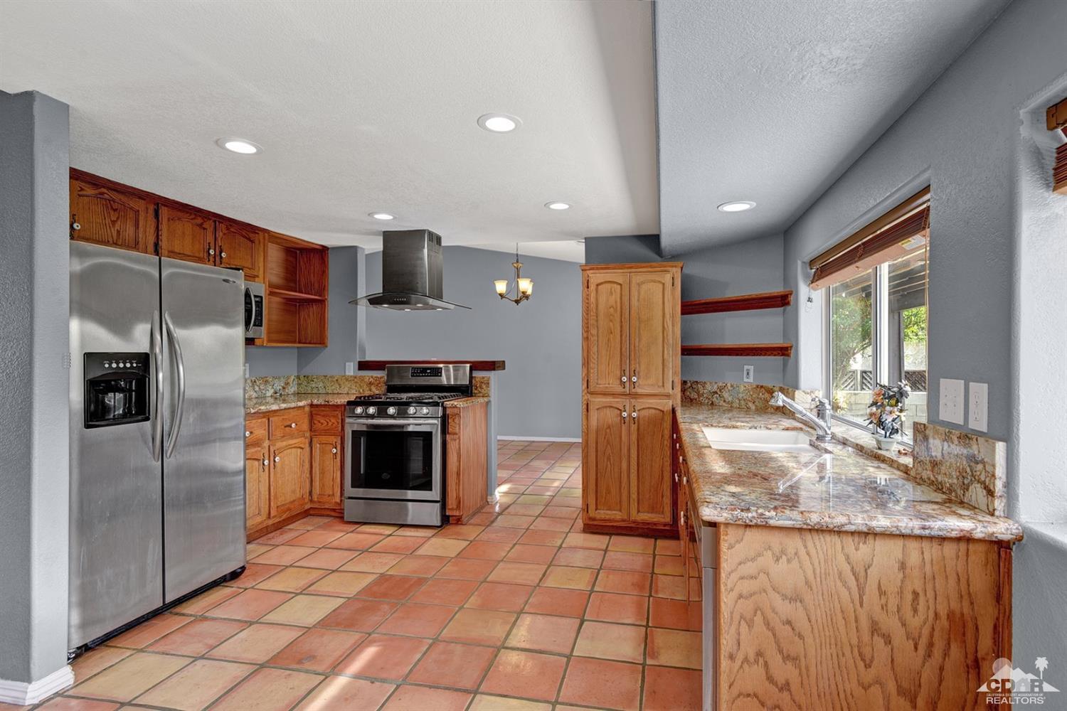 68889 Risueno Road Cathedral City, CA 92234 - Photo 8 of 29 a kitchen with stainless steel appliances granite countertop a refrigerator a stove and a sink