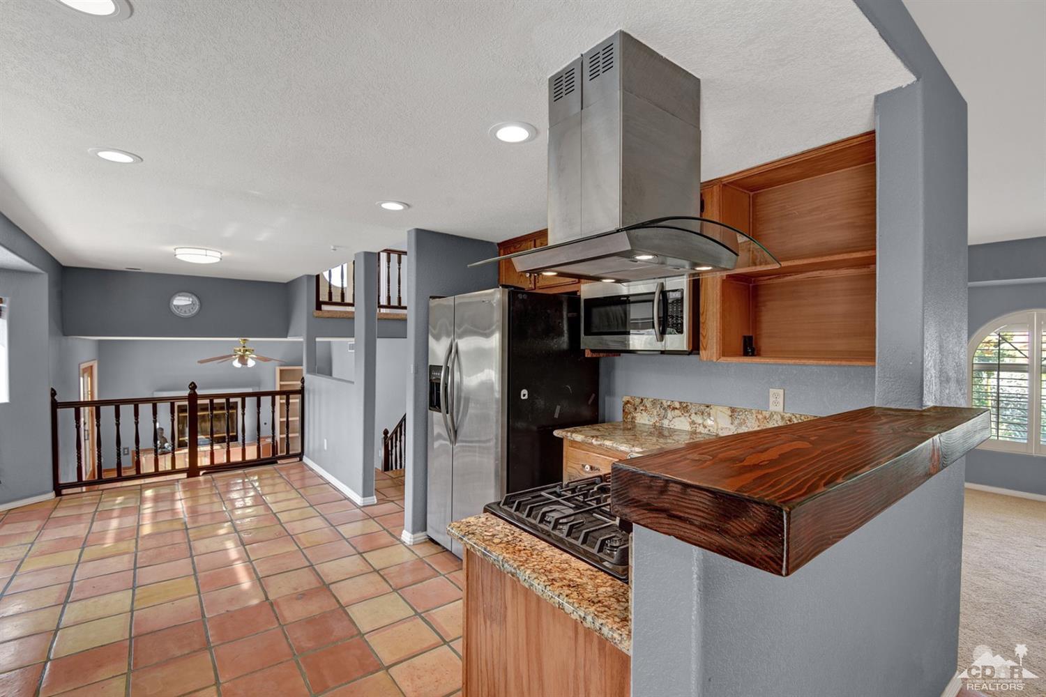 68889 Risueno Road Cathedral City, CA 92234 - Photo 9 of 29 a kitchen with stainless steel appliances granite countertop a stove and a refrigerator