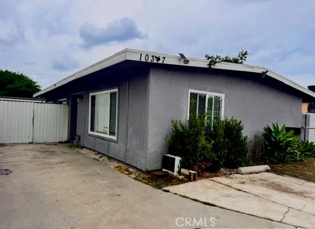a view of a house with a large window and wooden fence