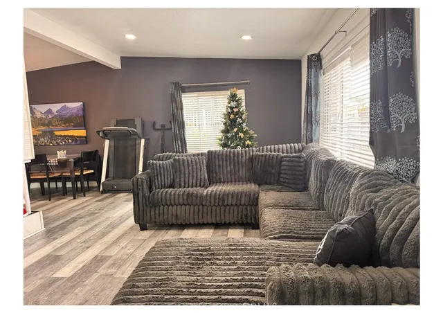 a living room with furniture a flat screen tv and a window