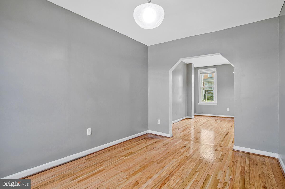 5204 Ivanhoe Avenue Baltimore, MD 21212 - Photo 12 of 38 a view of an empty room with wooden floor and a window