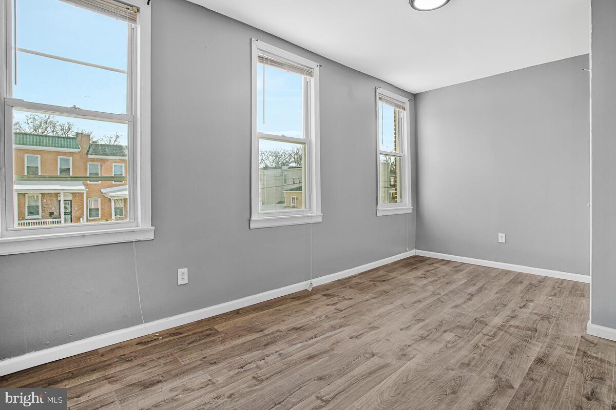 5204 Ivanhoe Avenue Baltimore, MD 21212 - Photo 17 of 38 a view of an empty room with wooden floor and a window