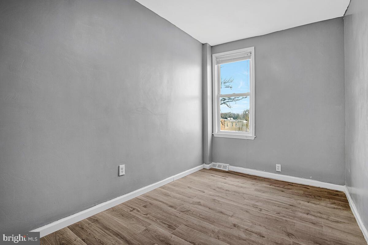 5204 Ivanhoe Avenue Baltimore, MD 21212 - Photo 20 of 38 a view of an empty room with wooden floor and a window