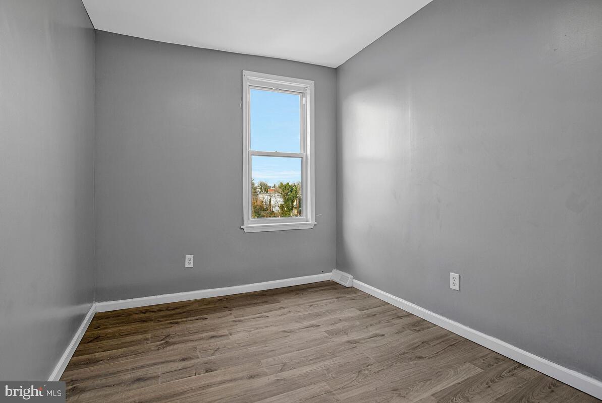5204 Ivanhoe Avenue Baltimore, MD 21212 - Photo 22 of 38 an empty room with wooden floor and windows