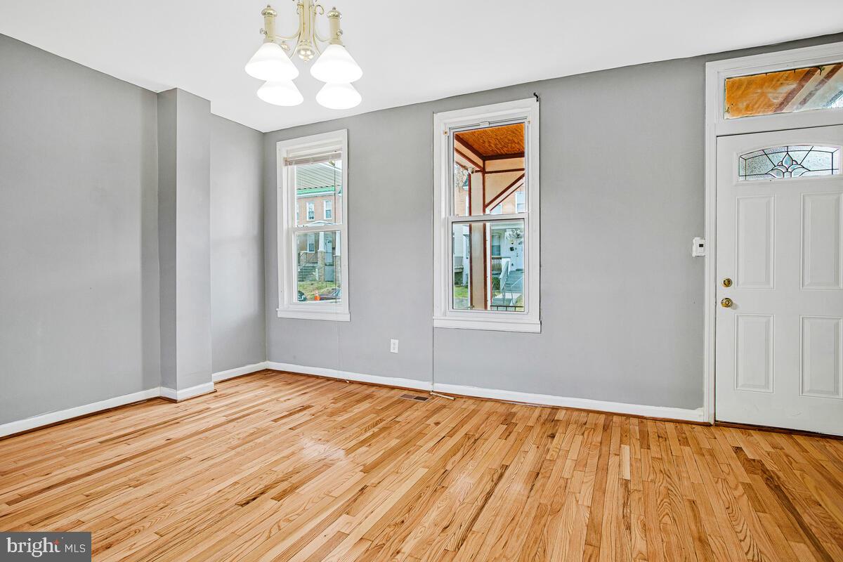 5204 Ivanhoe Avenue Baltimore, MD 21212 - Photo 9 of 38 a view of an empty room with window and wooden floor
