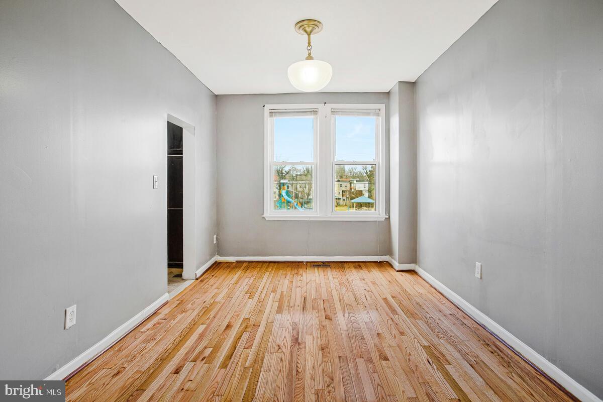 5204 Ivanhoe Avenue Baltimore, MD 21212 - Photo 10 of 38 a view of an empty room with wooden floor and a window