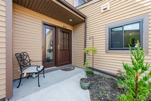 a view of a chair and table in backyard of the house