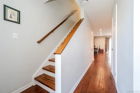 a hallway with wooden floor and staircase