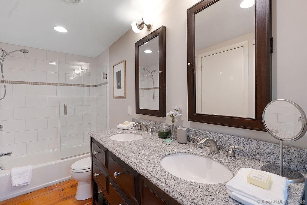 143 Melius Road Warren, CT 06754 - Photo 34 of 35 a bathroom with a granite countertop sink toilet a large mirror a bathtub and shower