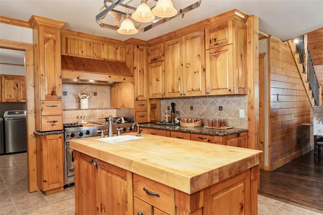 a kitchen with a sink a stove and cabinets