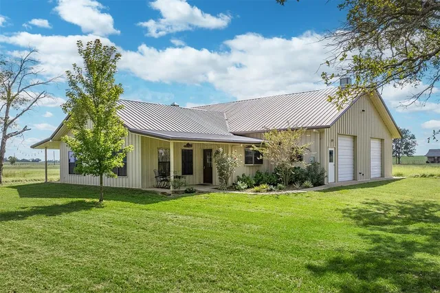 a front view of a house with a yard and trees