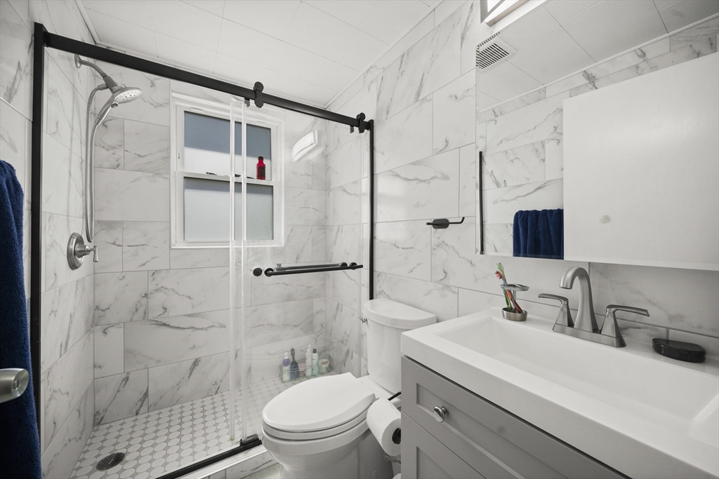 183-185 Middle Street Springfield, MA 01104 - Photo 13 of 27 a bathroom with a sink toilet a mirror and shower