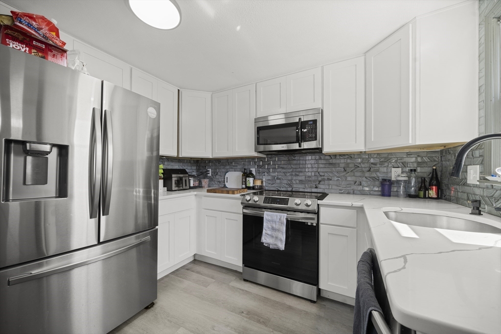183-185 Middle Street Springfield, MA 01104 - Photo 4 of 27 a kitchen with stainless steel appliances a refrigerator sink and microwave