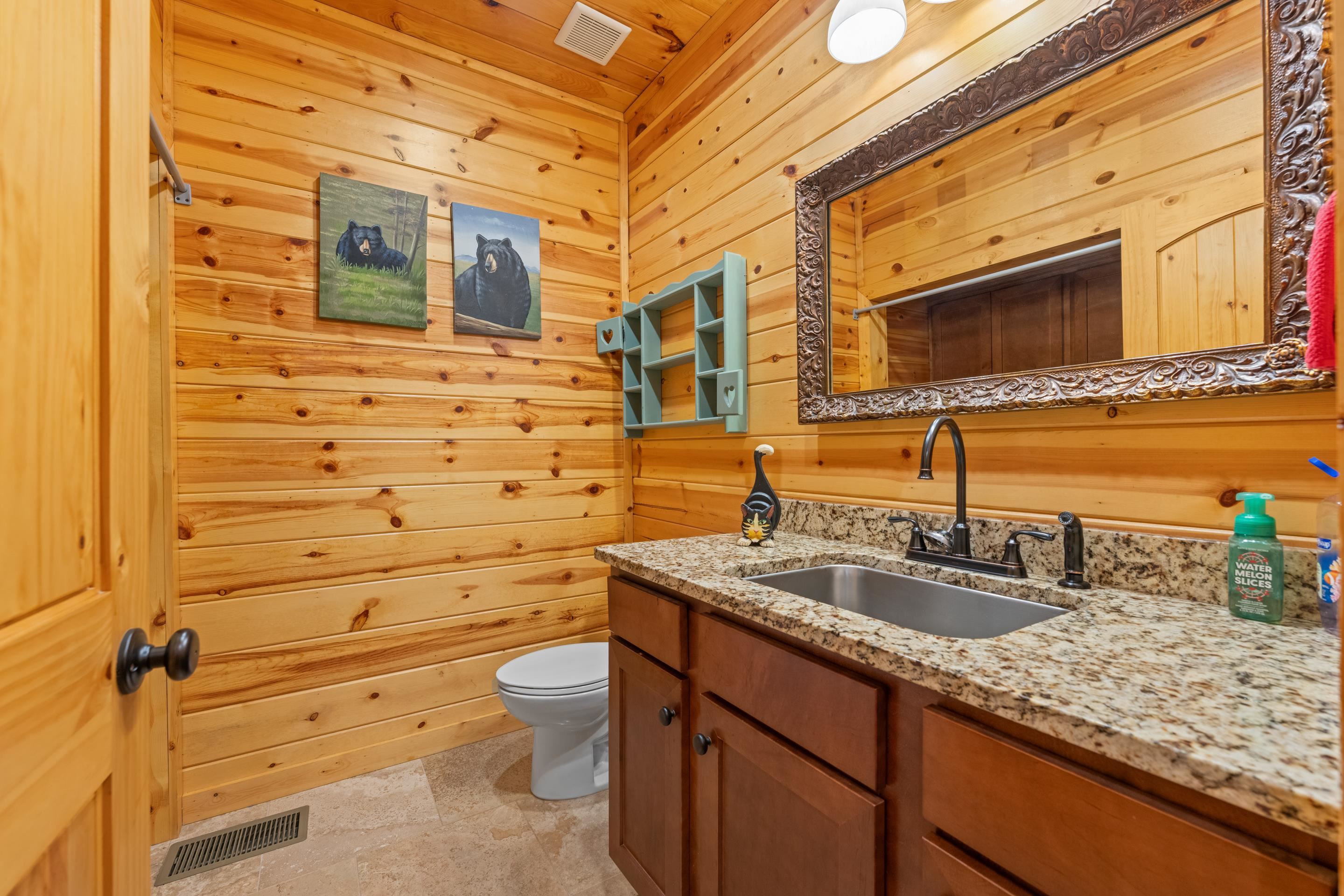 950 Cherry Road Eads, TN 38028 - Photo 20 of 30 Bathroom featuring natural wood plank walls, a dark wood vanity with a light granite countertop, an undermount sink, and an ornate framed mirror