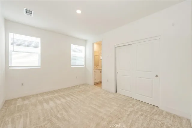 an empty room with windows and closet