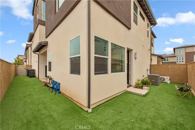 a view of a white house with a big yard and large windows
