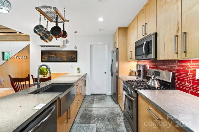 a kitchen with stainless steel appliances granite countertop a stove a sink and a microwave