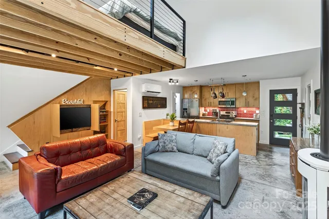 a living room with furniture kitchen view and a large window