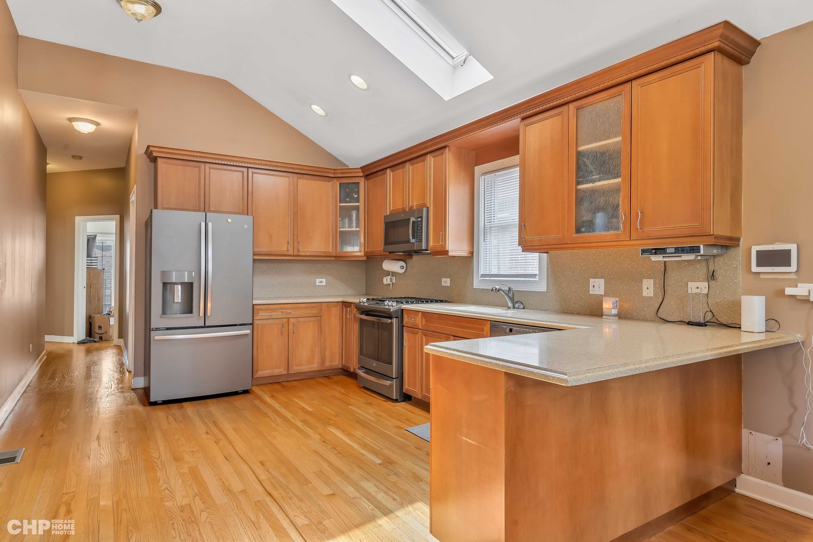 2931 North Rutherford Avenue Chicago, IL 60634 - Photo 6 of 37 a kitchen with stainless steel appliances granite countertop a refrigerator a sink dishwasher a stove and white countertops with wooden floor