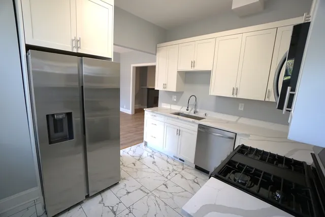 a kitchen with a sink a refrigerator and cabinets