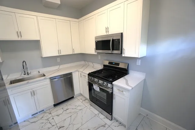 a kitchen with stainless steel appliances granite countertop a sink and a stove top oven