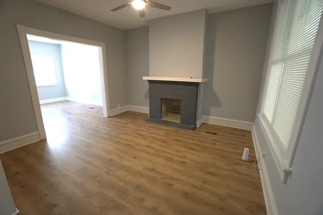 an empty room with wooden floor and fireplace