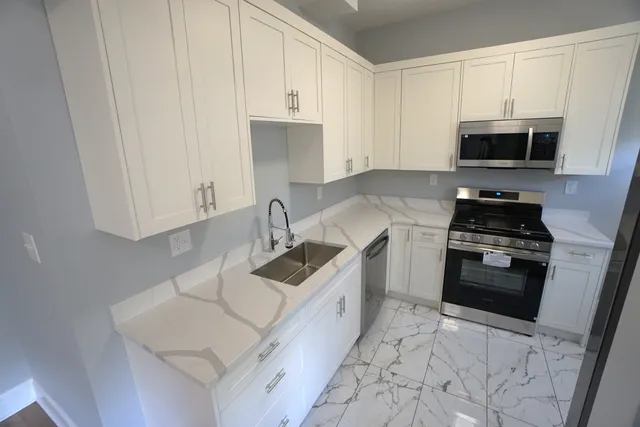 a kitchen with granite countertop a sink a stove and cabinets
