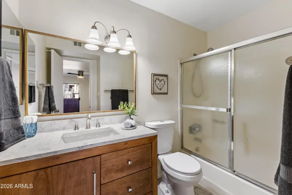 a bathroom with a granite countertop sink toilet and shower