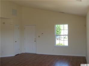 3040 Rockingham Court Southwest Concord, NC 28025 - Photo 5 of 14 an empty room with wooden floor and windows