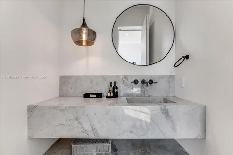 a kitchen with kitchen island granite countertop a stove a sink a dining table and chairs with wooden floor