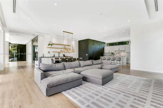 a living room with fireplace furniture and a large window
