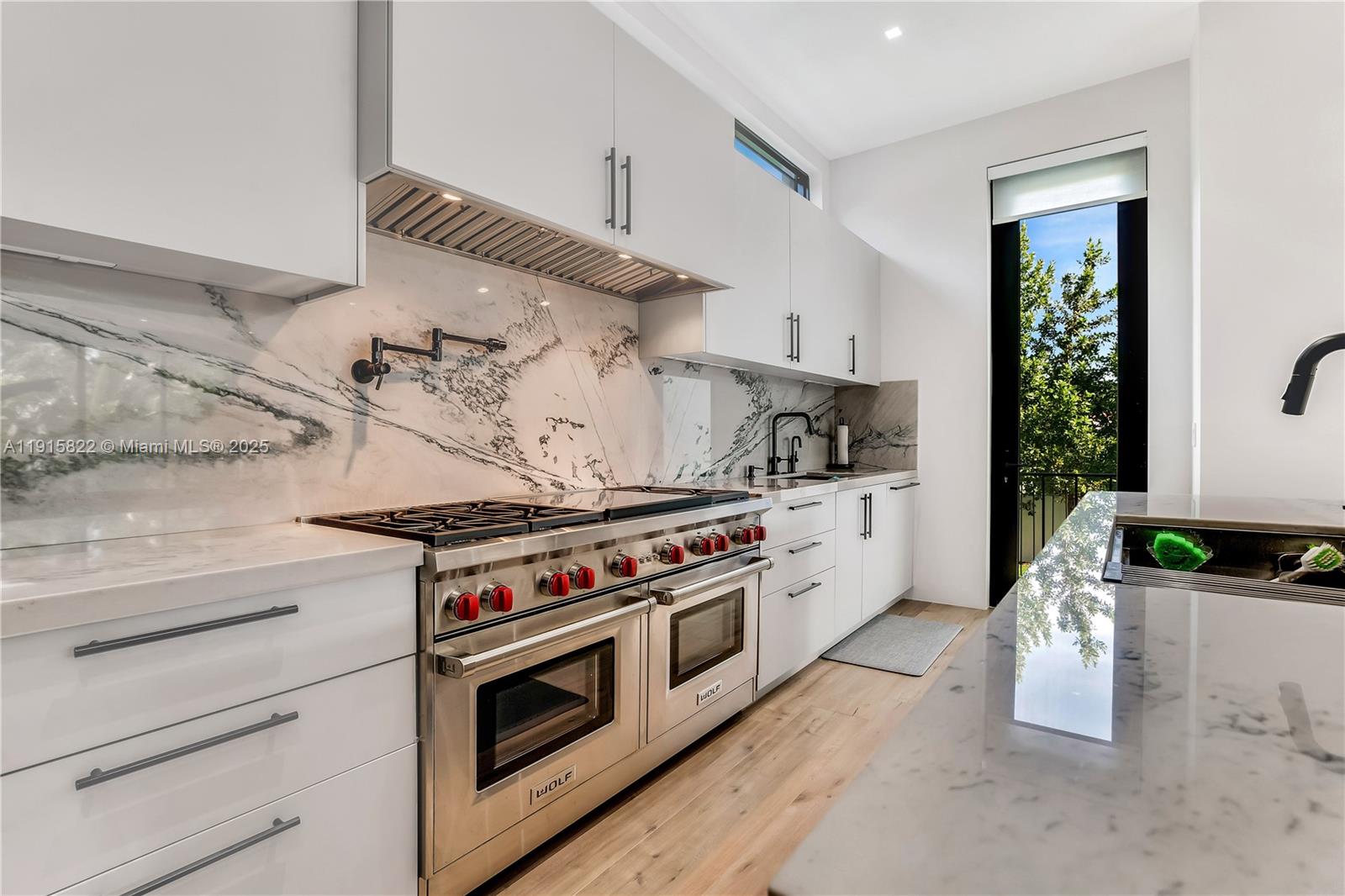 9045 Hawthorne Avenue Surfside, FL 33154 - Photo 27 of 61 a kitchen with a stove and white cabinets