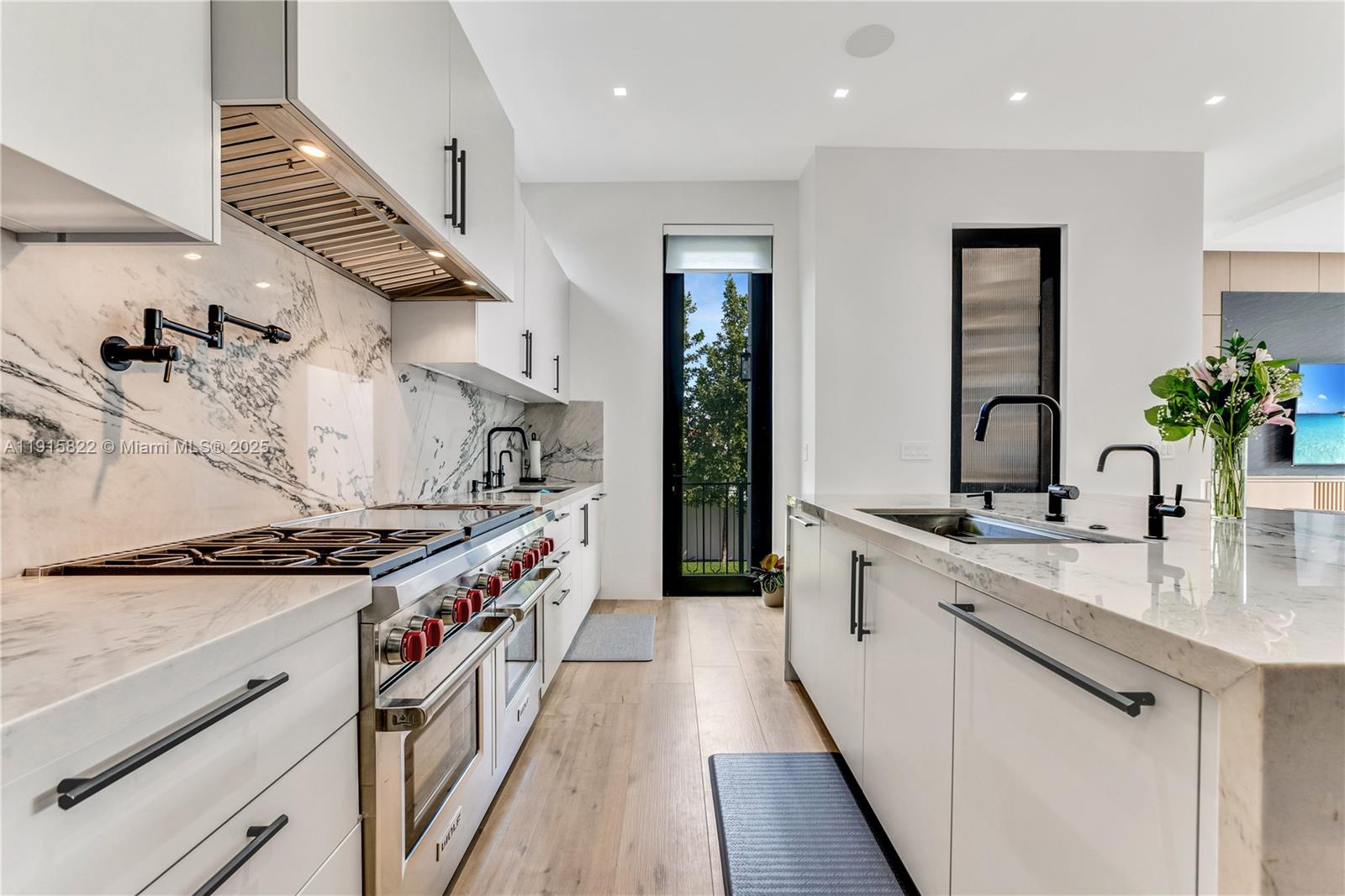 9045 Hawthorne Avenue Surfside, FL 33154 - Photo 28 of 61 a kitchen with stainless steel appliances granite countertop a sink stove and cabinets