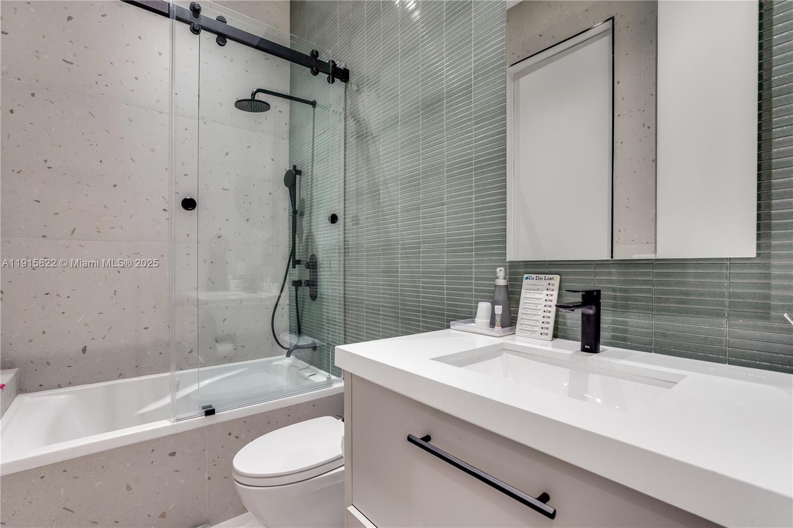 9045 Hawthorne Avenue Surfside, FL 33154 - Photo 43 of 61 a bathroom with a granite countertop toilet a sink and a bathtub